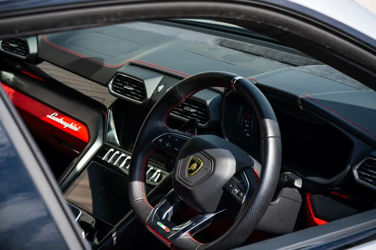 Photo taken through the window of a 2021 Lamborghini Urus V8 Auto showing the Steering wheel