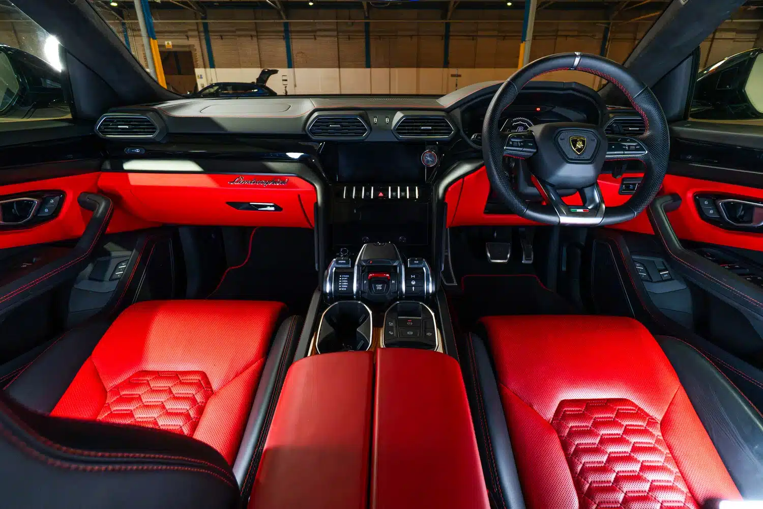 Interior of a 2021 Lamborghini Urus V8 Auto, showing the bold, red leather trim on the dashboard