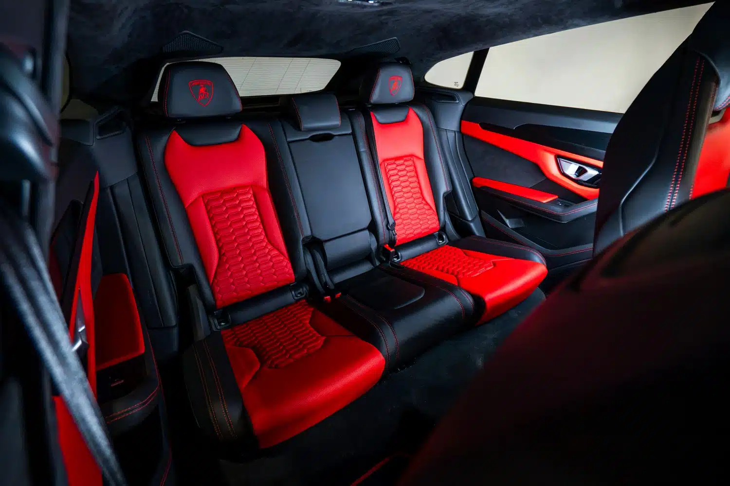 Interior of a 2021 Lamborghini Urus V8 Auto, showing the vivid red, leather, rear passenger seats.