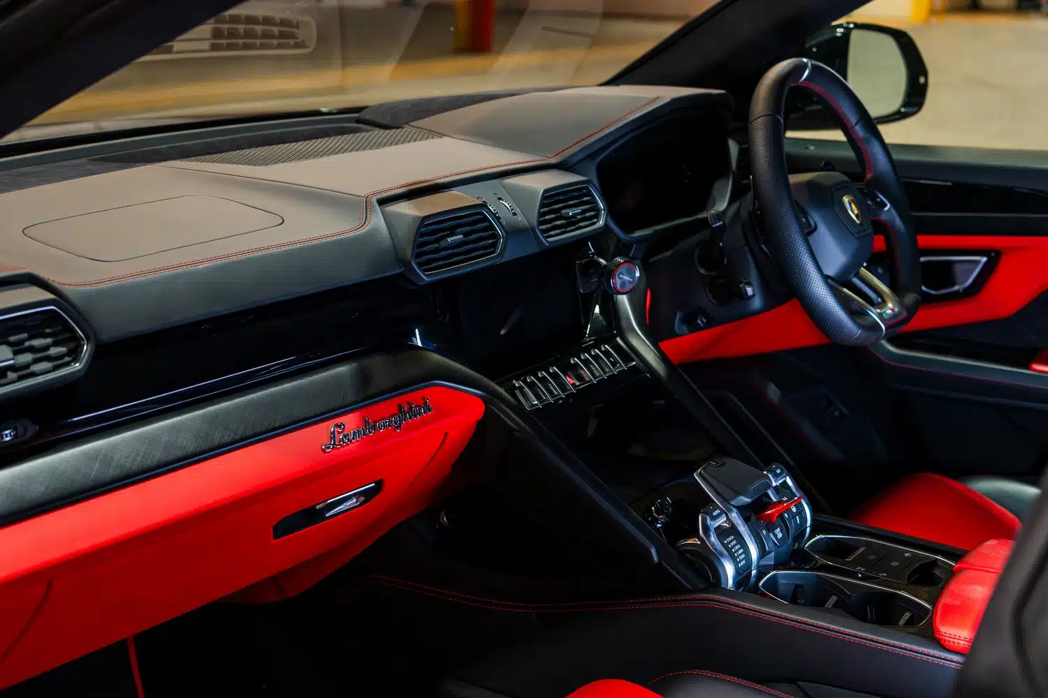 Interior of a 2021 Lamborghini Urus V8 Auto, showing the bold, red leather trim on the dashboard