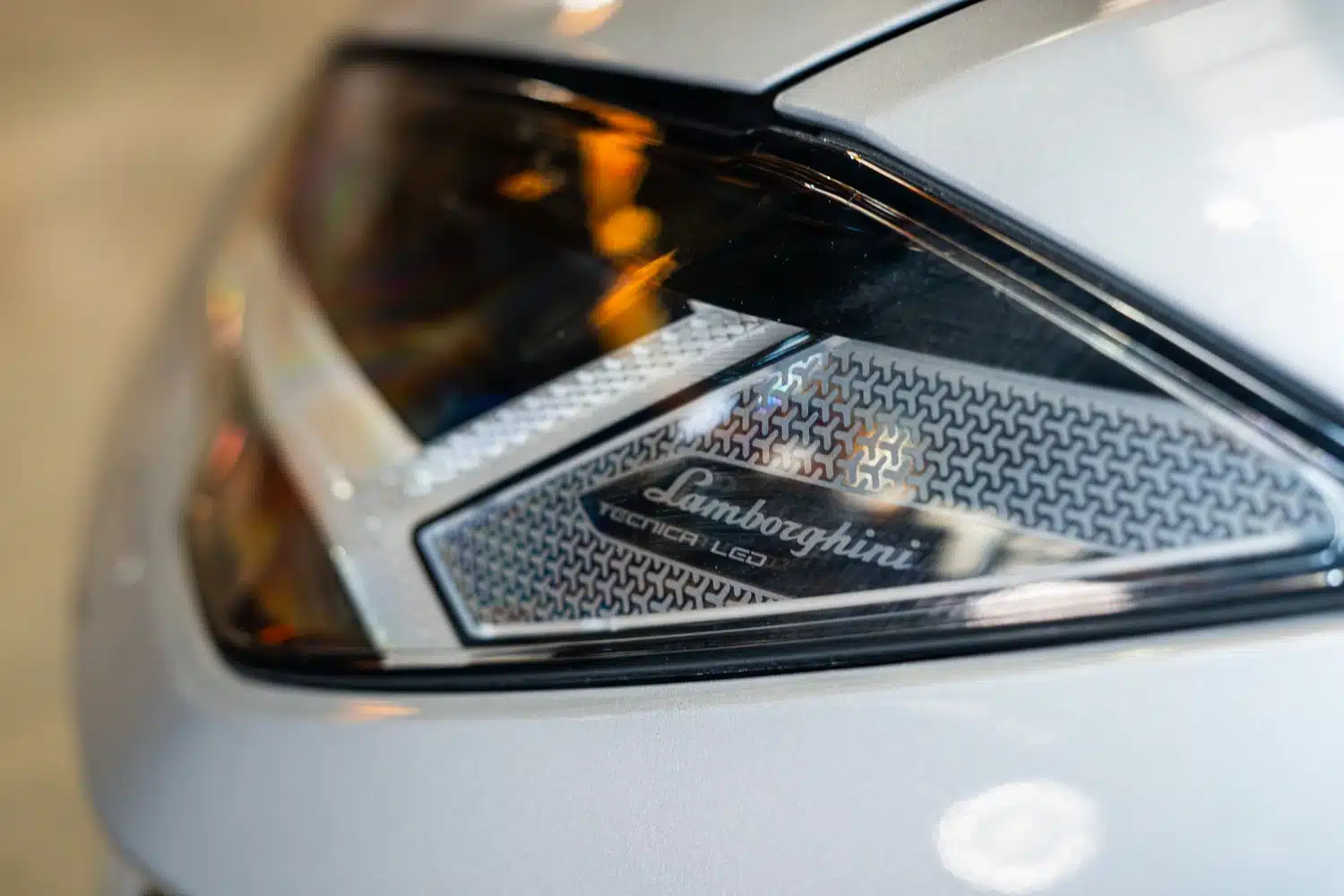 Close up photo of the Lamborghini logo within the headlight of a 2021 Lamborghini Urus V8 Auto
